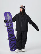Model wearing the black sparkle ski suit set holding a snowboard