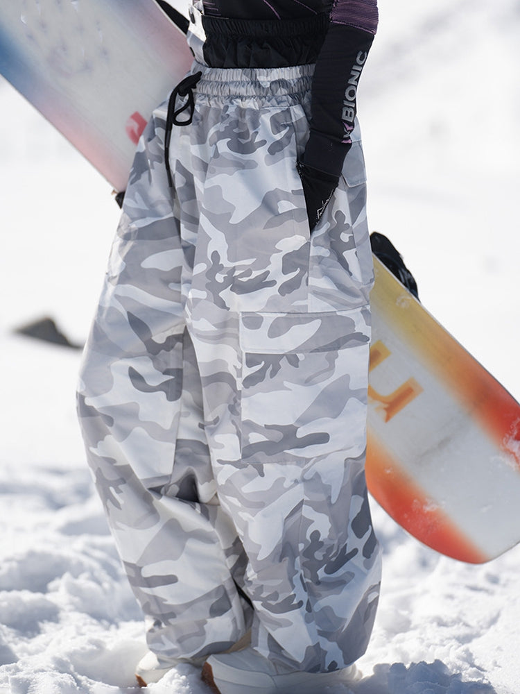 Gray camo baggy snow pants with a snowboard, side view