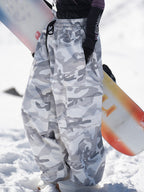 Gray camo baggy snow pants with a snowboard, side view