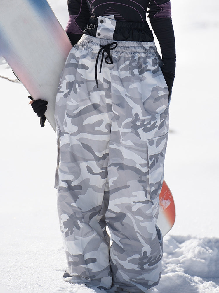 Woman wearing gray camo baggy snowboard pants in the snow, front view
