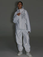 White ski jacket and pants set photographed in low light
