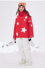 Child model in red insulated ski jacket standing in the snow