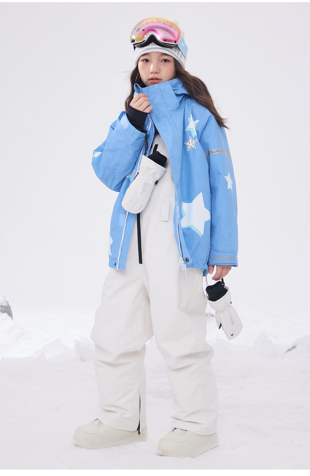 Child wearing light blue 3L ski jacket with white snow bibs