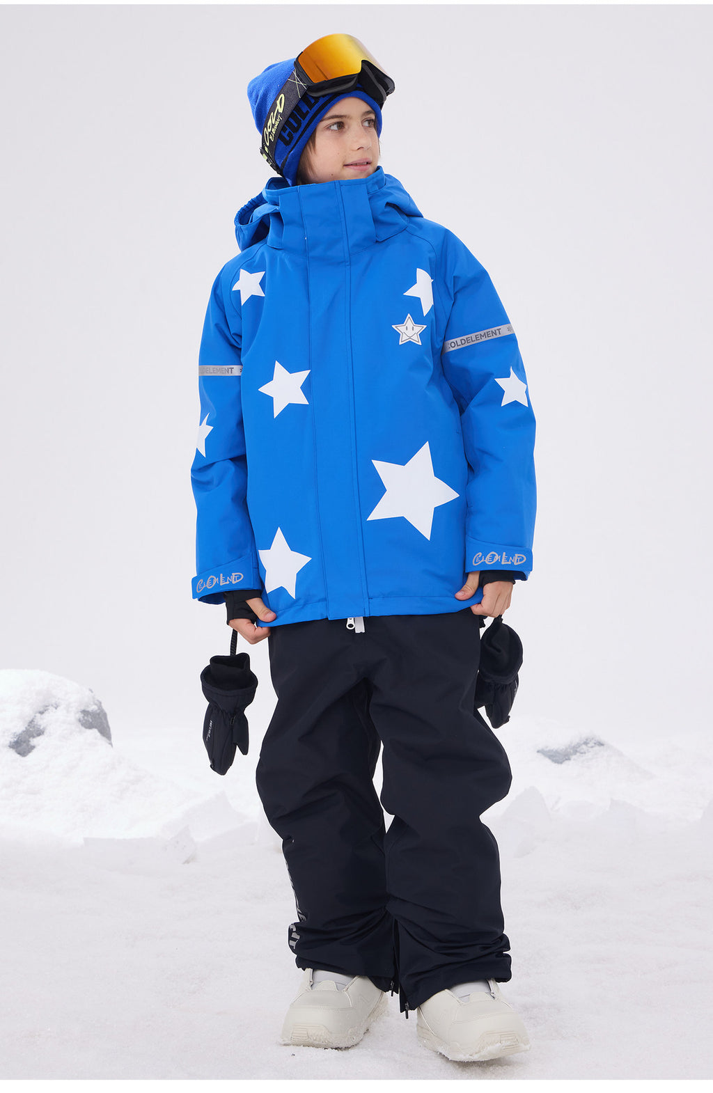 Boy in blue star print ski jacket with black snow pants