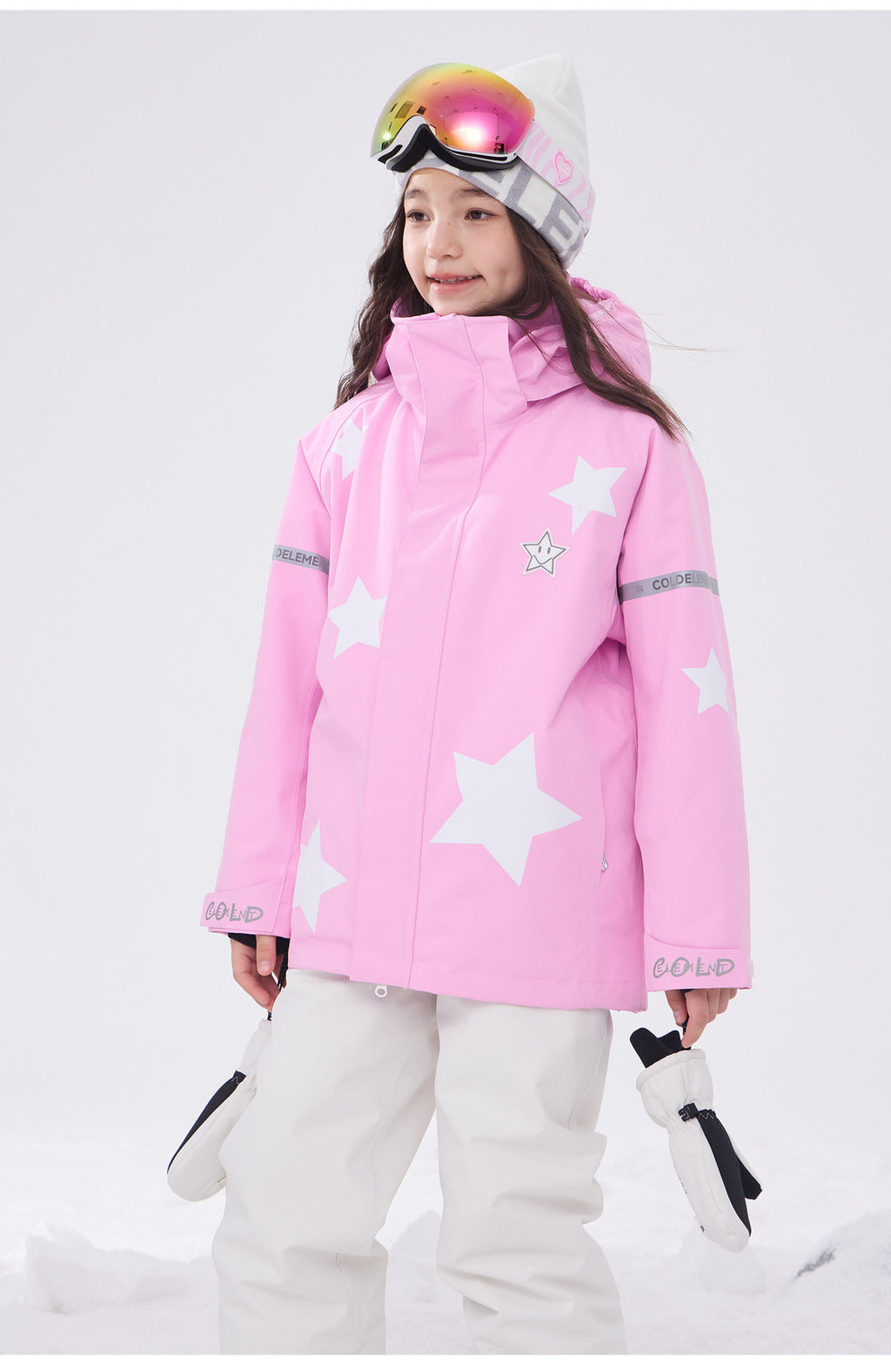 Girl in pink kids ski jacket with star print in the snow