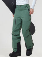 Men's insulated ski pants in Green worn with a snowboard