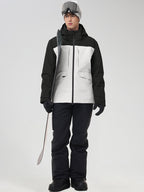 Men's black and white color-block ski jacket with black pants, holding ski poles