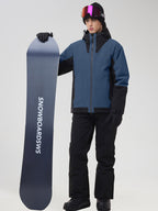 Men's blue ski jacket and black snow pants set, holding a snowboard